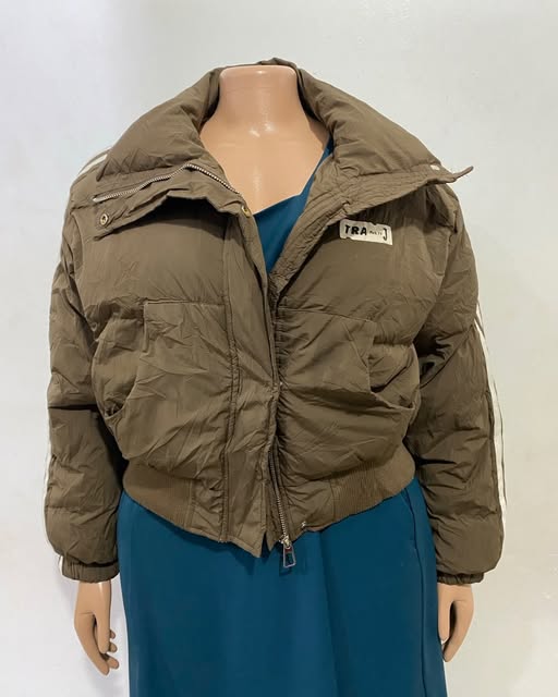 Olive padded jacket shown on a mannequin at TAG-her